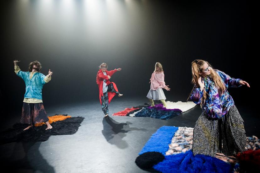 Four dancers wearing colourful clothes.