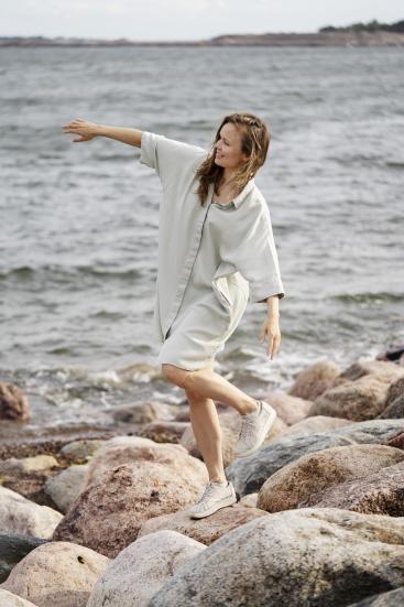 Mari Pajunpää dancing on seashore in white clothes