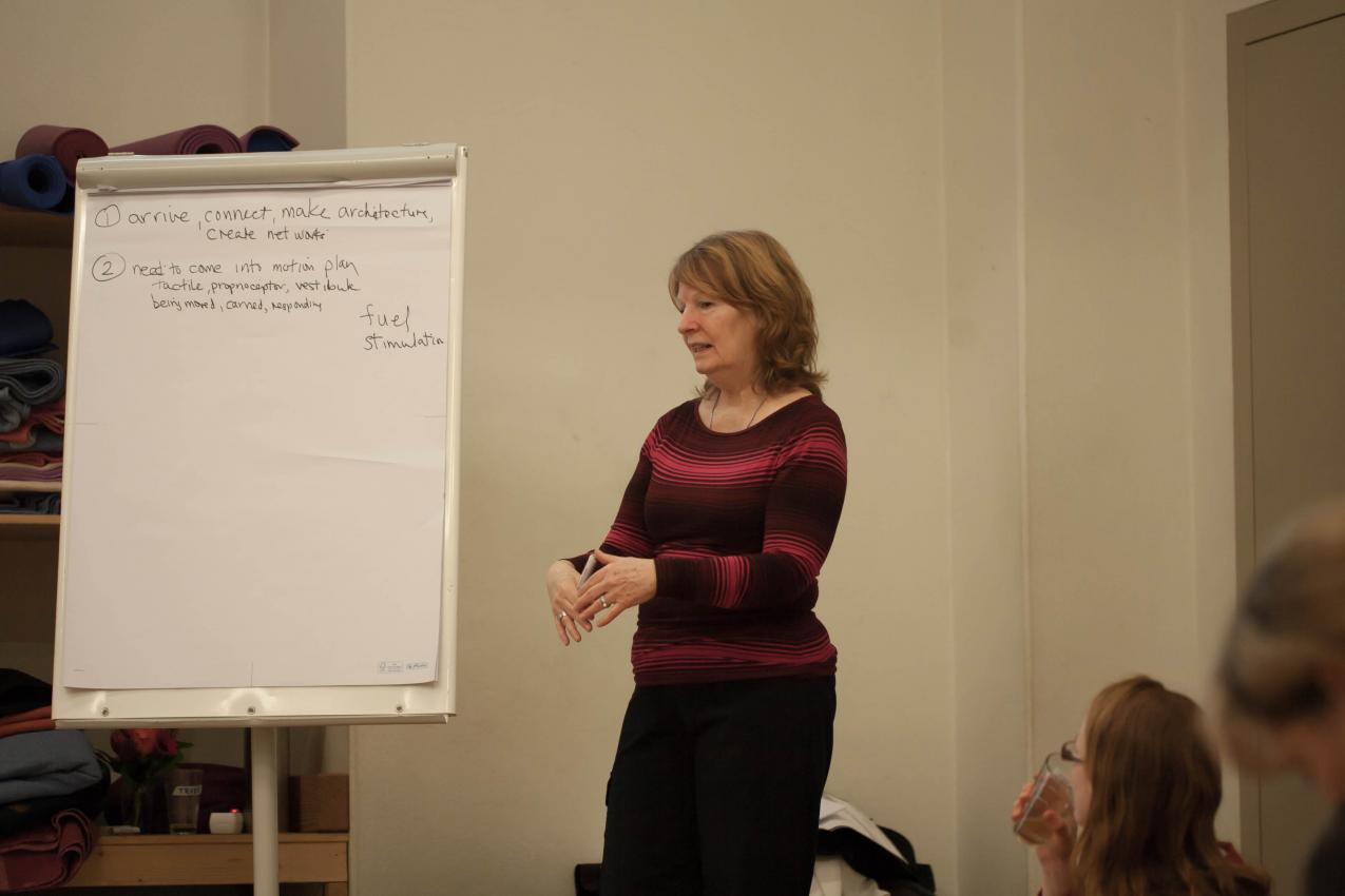 A person talking in front of a flip chart