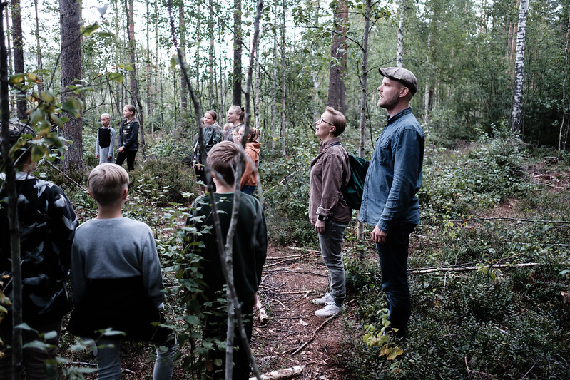 Lapsia ja aikuisia laulamassa metsässä