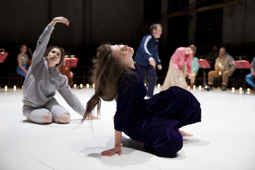 Dancers Eleni Pierides and Anna Kupari. The performance's orchestra is visible at the back.