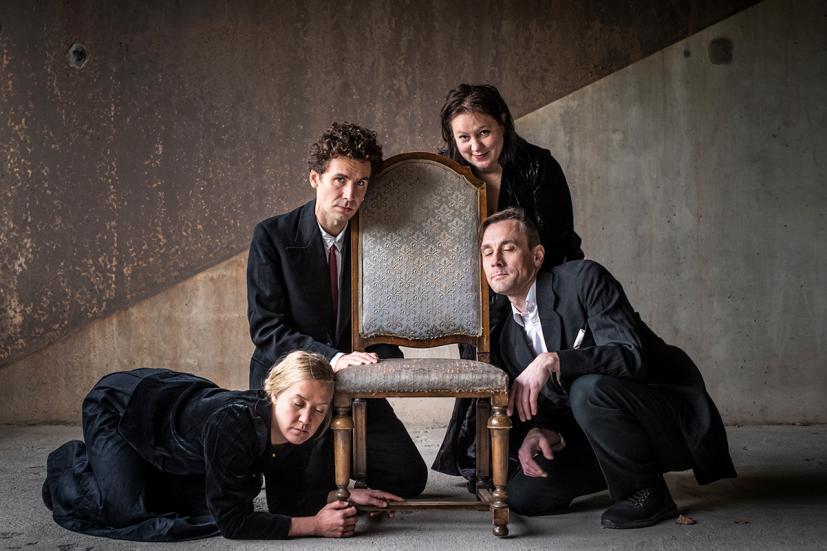 Four people leaning on an old fashioned chair