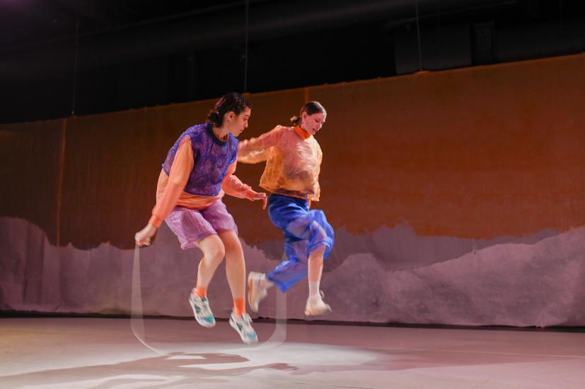 Two dancers skipping rope together.