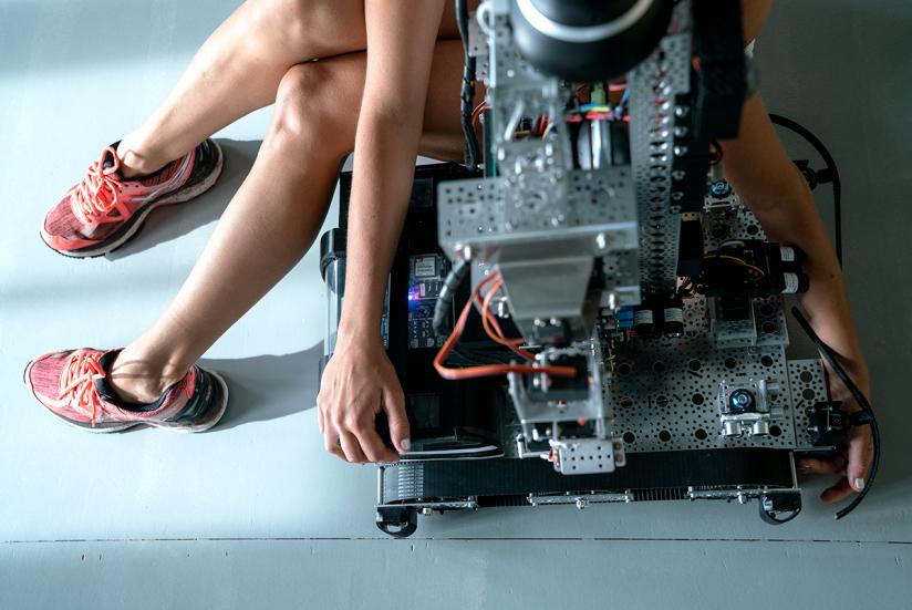 A dancer sitting on top of a robot, or on its lap