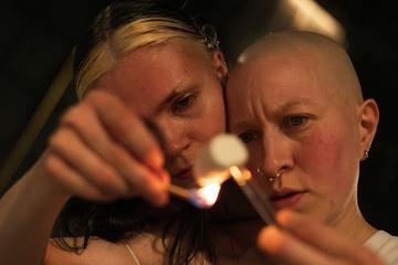 Two people looking at a lit match