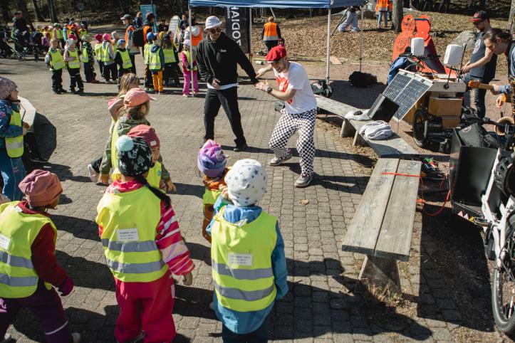 Two dancers dancing, surrounded by a group of children