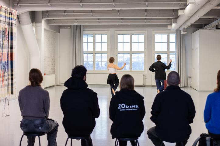 Kansainvälisiä vieraita katsomassa demoa studiossa.
