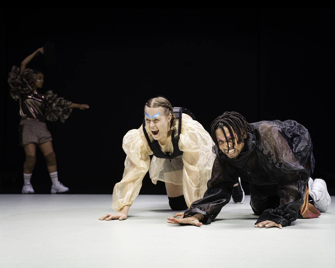 Two people on the floor on all fours. The look like they are screaming.