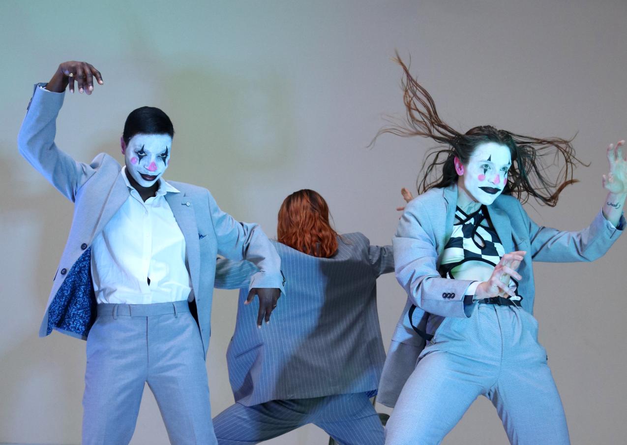 Three performers in blue suits