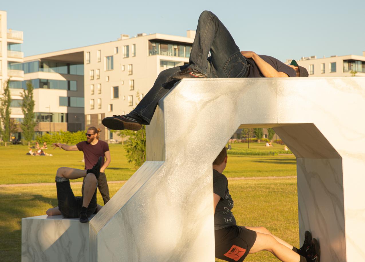 A person is standing on a wall, looking down. The camera is situated below them.