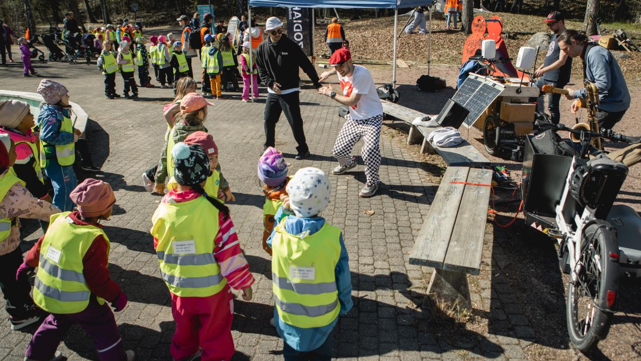 Two dancers dancing, surrounded by a group of children