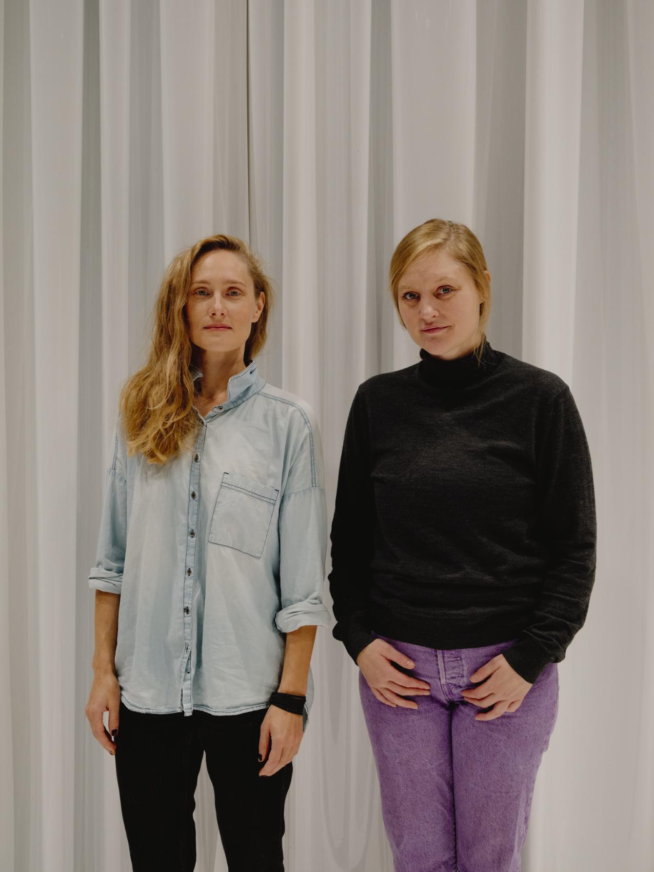 Karolina Ginman ja Sinna Virtanen seisovat valkoisen verhon edessä