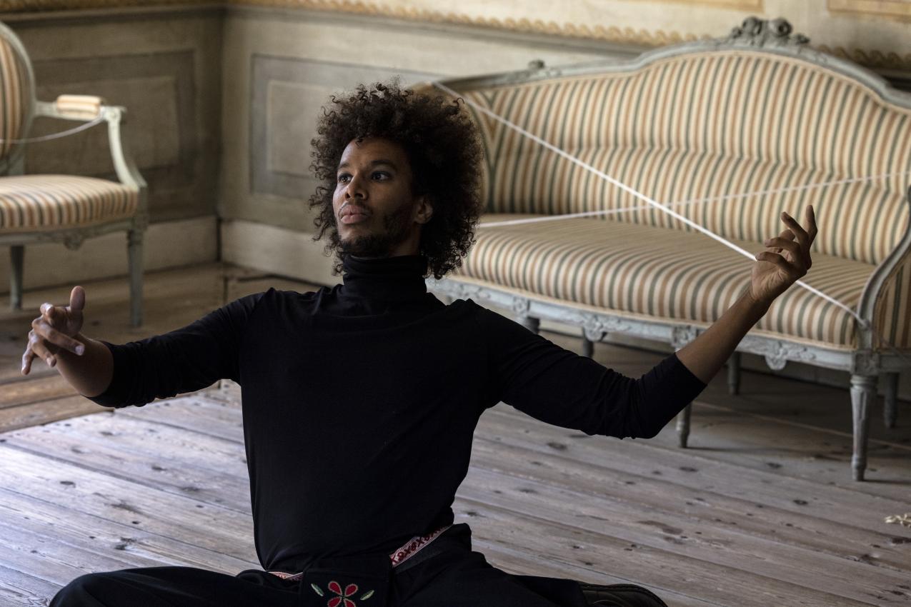 Marlon Moilanen sitting on the floor, hands wide apart