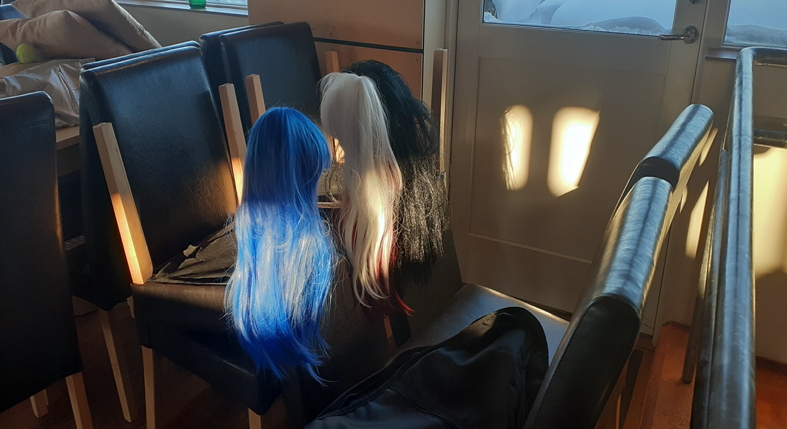 three wigs on a chair