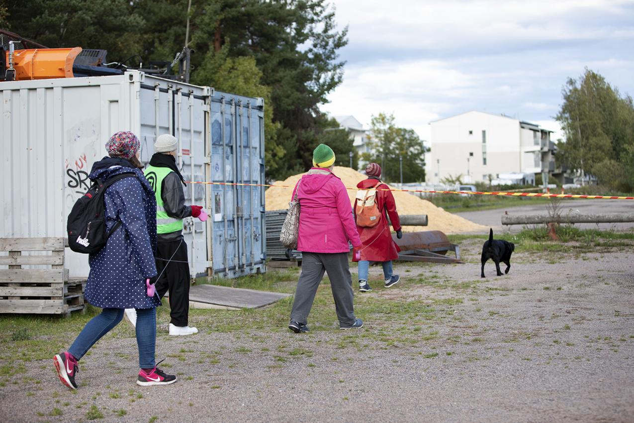 Ihmisiä kävelyllä lähiömaisemassa