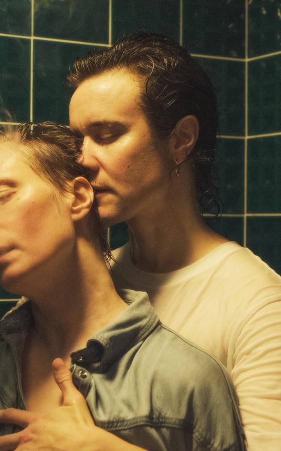 Ennakkokuva. kaksi henkilö seisovat suihkutilassa. Tilan seinät on päällystetty vihreillä kaakeleilla.