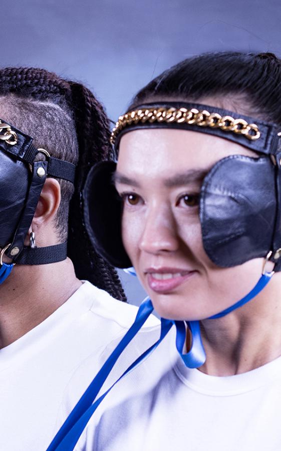 Marketing photo featuring two people. They have blinkers for horses on their face.