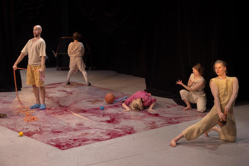 Five performers on stage. The floor is tinted purple.