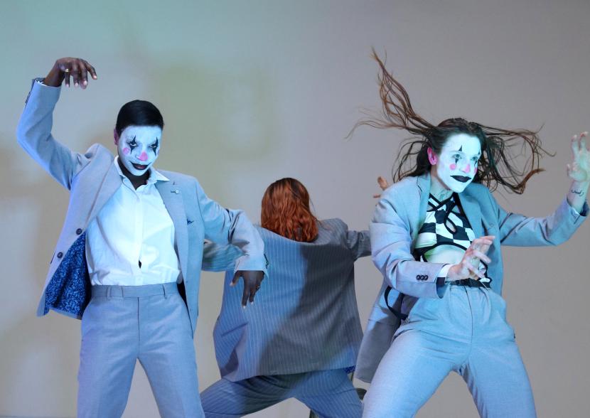 Three performers in blue suits