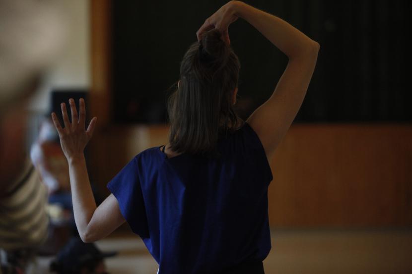Maija Reeta Raumanni her back heading the camera. Her hands are raised abowe her head. The backround is blurry.